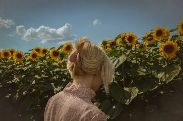 Femme souriante dans un champ de tournesols